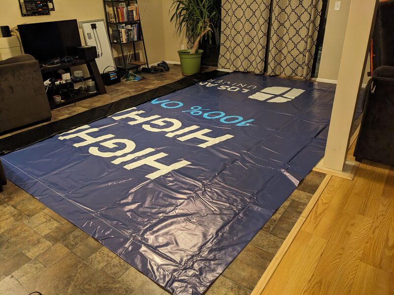 Vinyl tarp laid out on the floor, ready to be cut